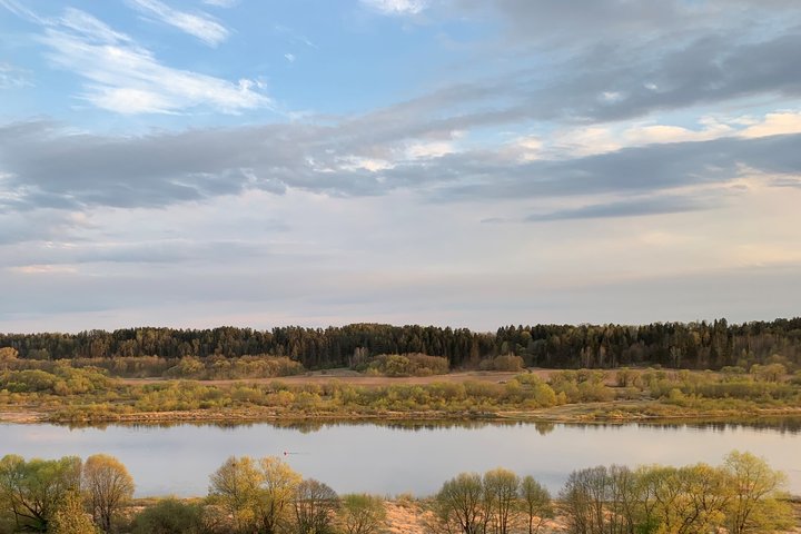 Dangus, medžiai, vandens telkinys.