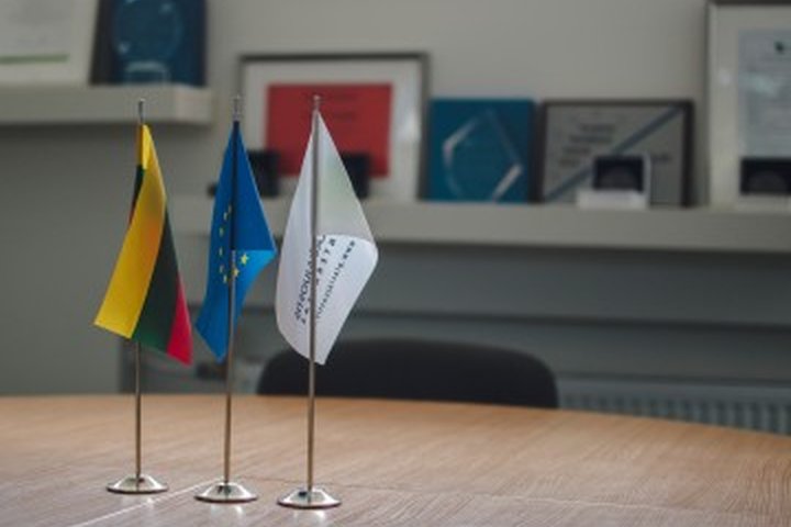 Stovinčios ant stalo Lietuvos, Europos Sąjungos vėliavos, vėliava su VšĮ „Plačiajuostis internetas" logotipu.